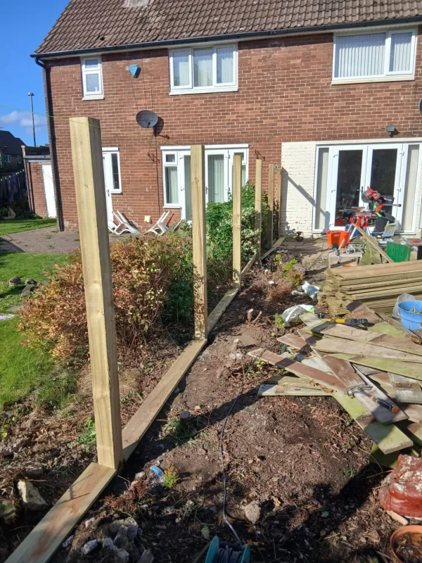 New posts in place after removal of the old fence, with installation under way.